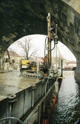 Dotěsnění stavební jímky ze štětovnic clonou z tryskové injektáže, oprava pilířů č. 8 a 9 Karlova mostu v Praze