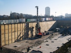 A foundation pit secured by rider bracing consisting of pairs of profiles type U300 without soldier beams with embedded anchors; reinforced concrete piles are being bored at the bottom; the BB Centre in Prague
