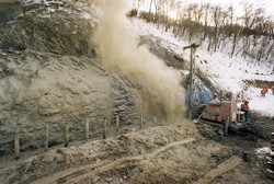 Realizace svislých prvků budoucího mikrozáporového pažení pod zeminovou lavicí, zajištěnou stříkaným betonem; Nové spojení, Praha